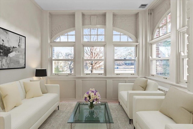 living room with a decorative wall and visible vents