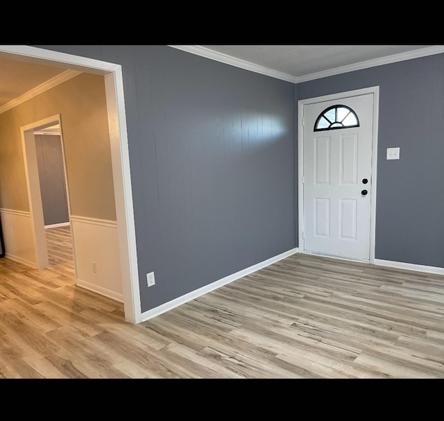 entryway with light wood-type flooring and ornamental molding