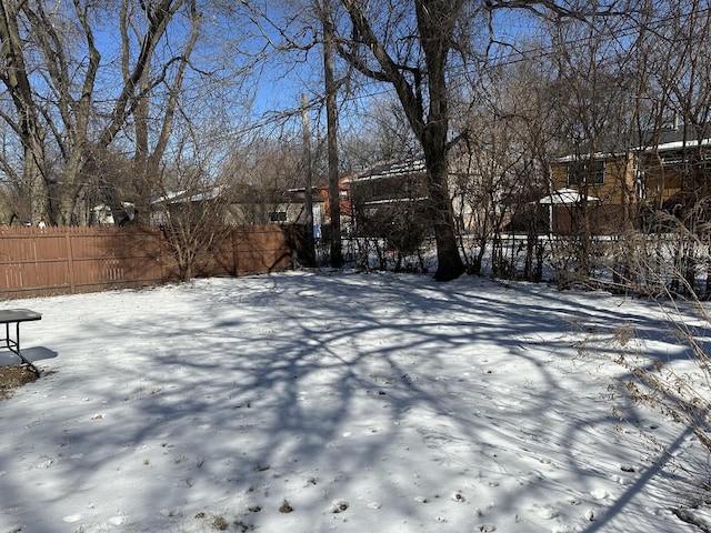 yard layered in snow with fence