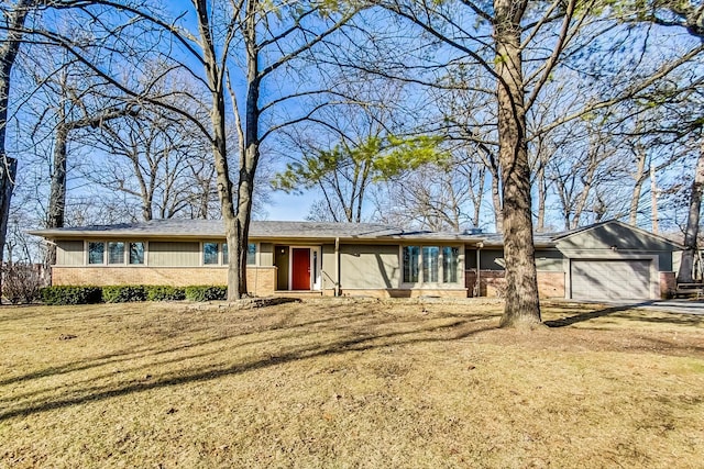 ranch-style house with a garage, brick siding, and a front lawn