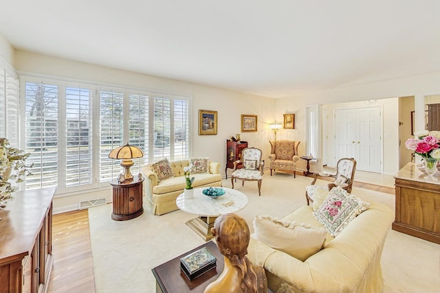 living room with light wood finished floors and visible vents