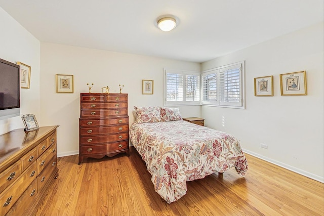 bedroom with light wood-type flooring and baseboards