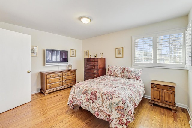 bedroom featuring light wood-style floors and baseboards