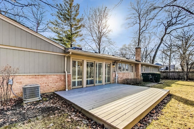 deck featuring cooling unit, fence, and a yard