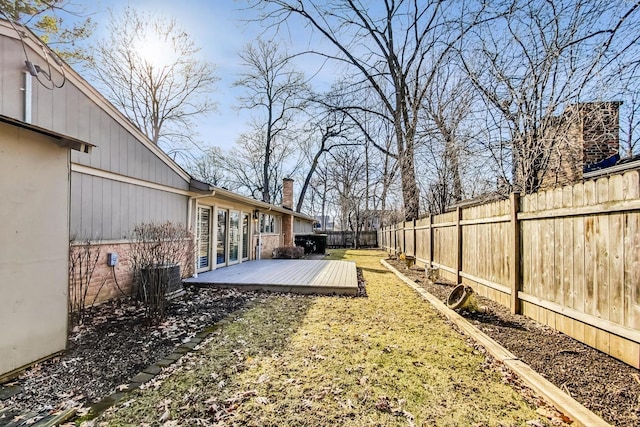 view of yard with a wooden deck and a fenced backyard