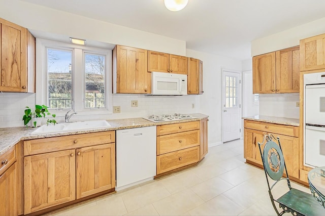 kitchen featuring a sink, white appliances, tasteful backsplash, and a healthy amount of sunlight