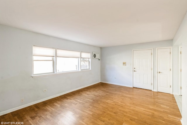 unfurnished room with light wood-style flooring and baseboards