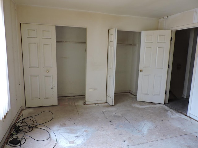 unfurnished bedroom with two closets