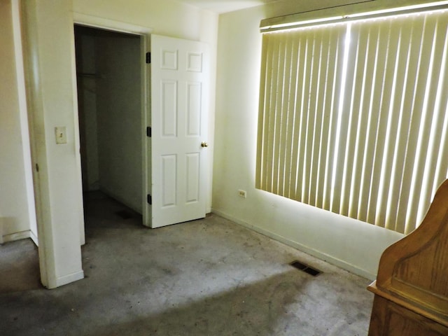 unfurnished bedroom featuring unfinished concrete floors and visible vents