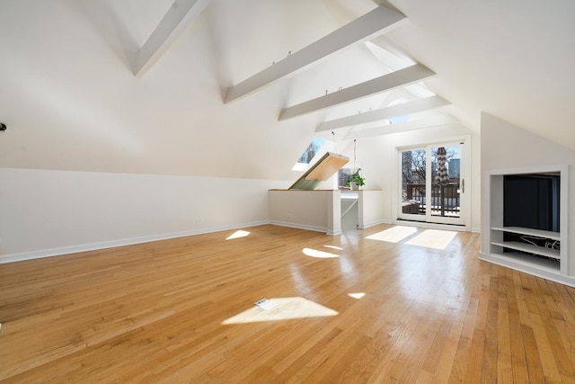 additional living space with baseboards, light wood-style flooring, and vaulted ceiling with beams