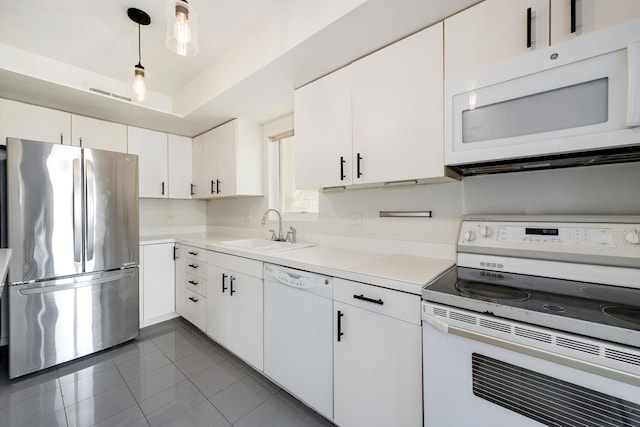 kitchen featuring a sink, white cabinetry, white appliances, light countertops, and a raised ceiling