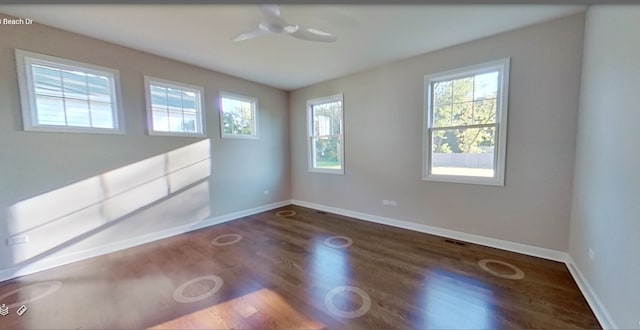 spare room with baseboards and wood finished floors