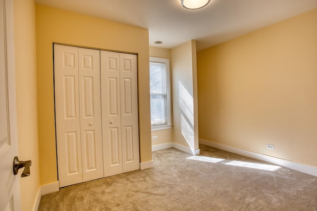 unfurnished bedroom featuring a closet, carpet flooring, and baseboards