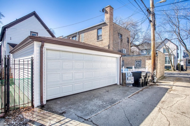 view of side of home featuring an outdoor structure, fence, a garage, and a chimney