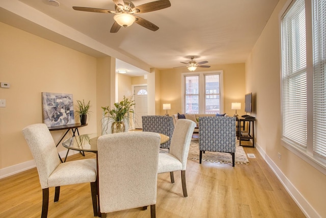 dining room with baseboards, light wood-style flooring, and a ceiling fan