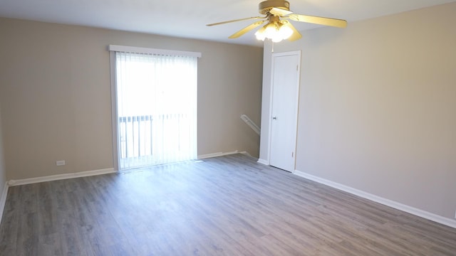 spare room featuring a ceiling fan, baseboards, and wood finished floors