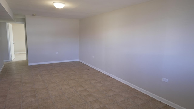 unfurnished room with baseboards