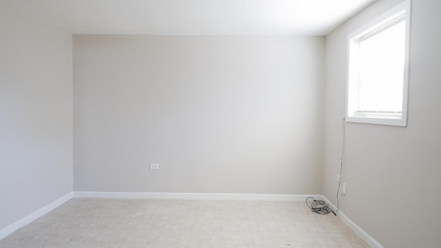 unfurnished room with baseboards