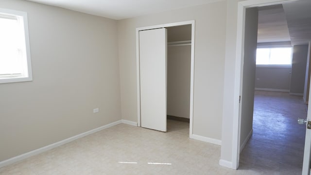 unfurnished bedroom with baseboards and a closet