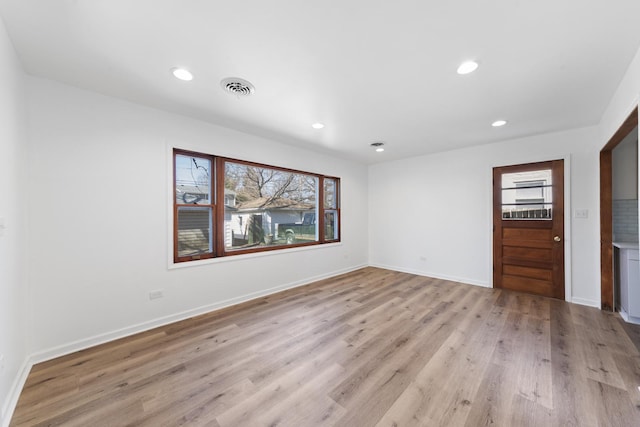 spare room with recessed lighting, visible vents, light wood-style flooring, and baseboards