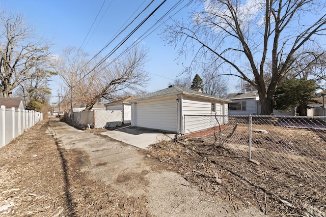 view of side of property with a garage, driveway, and fence