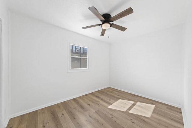 spare room featuring ceiling fan, wood finished floors, and baseboards