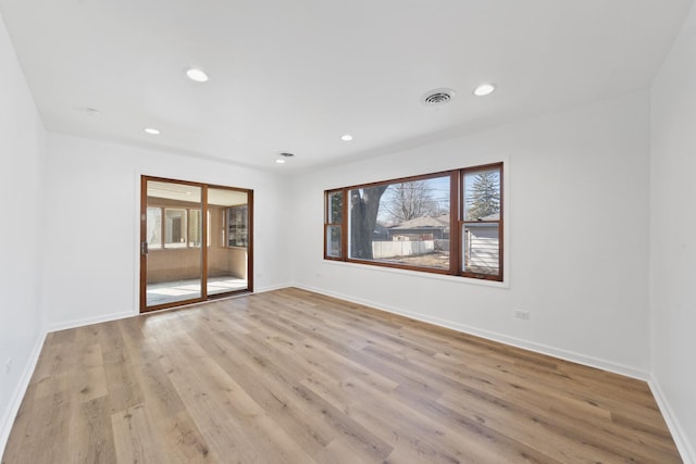 empty room featuring light wood-type flooring, baseboards, a wealth of natural light, and recessed lighting