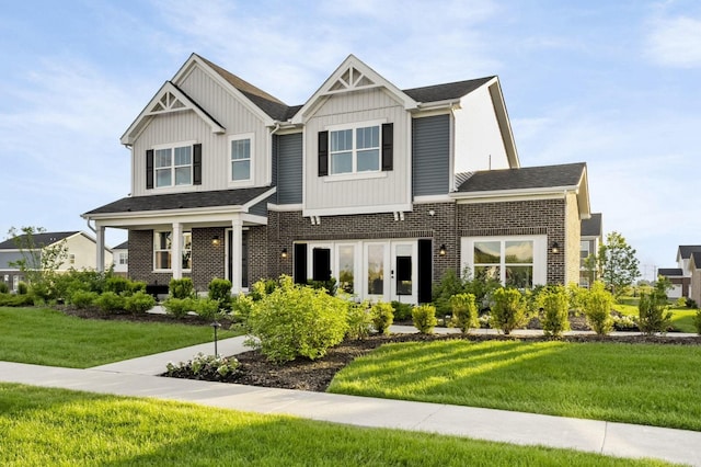 view of front facade with a front lawn, board and batten siding, and brick siding