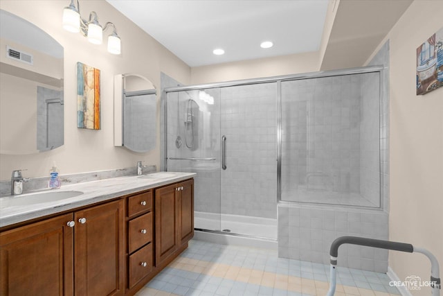 bathroom with visible vents, a shower stall, and a sink