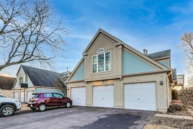 exterior space with aphalt driveway and an attached garage