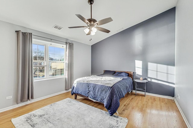 bedroom with visible vents, baseboards, and wood finished floors