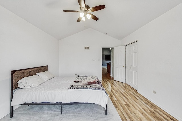 bedroom with visible vents, a closet, light wood-style floors, ceiling fan, and vaulted ceiling