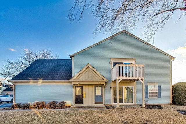 view of front of house with a balcony and roof with shingles