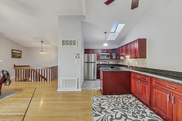 kitchen with dark brown cabinets, visible vents, dark countertops, and appliances with stainless steel finishes