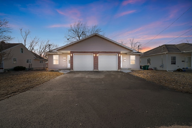 view of front of house featuring a garage, brick siding, and driveway