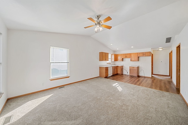 unfurnished living room with carpet, lofted ceiling, baseboards, and visible vents