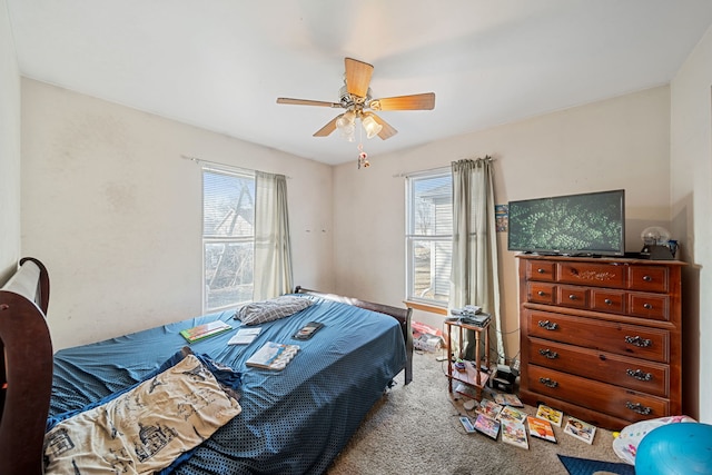 bedroom with multiple windows, a ceiling fan, and carpet flooring