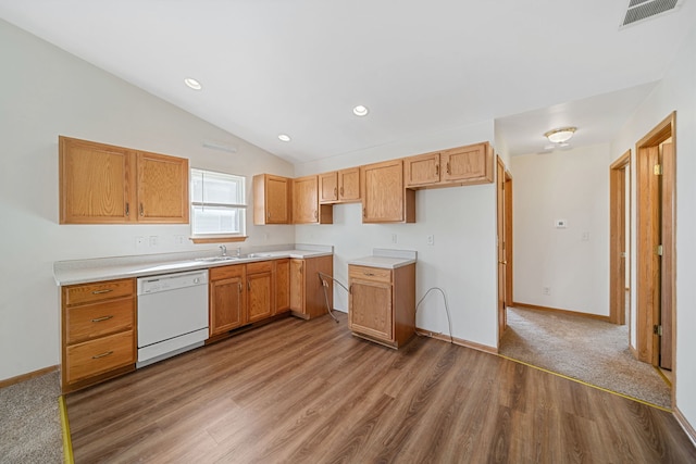 kitchen with visible vents, a sink, wood finished floors, white dishwasher, and vaulted ceiling