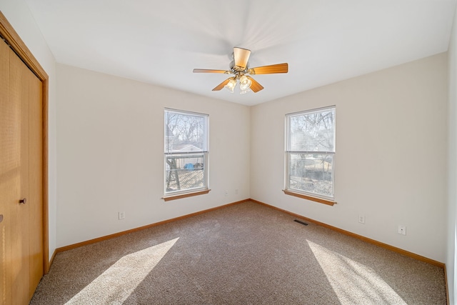 unfurnished bedroom featuring a closet, multiple windows, and baseboards