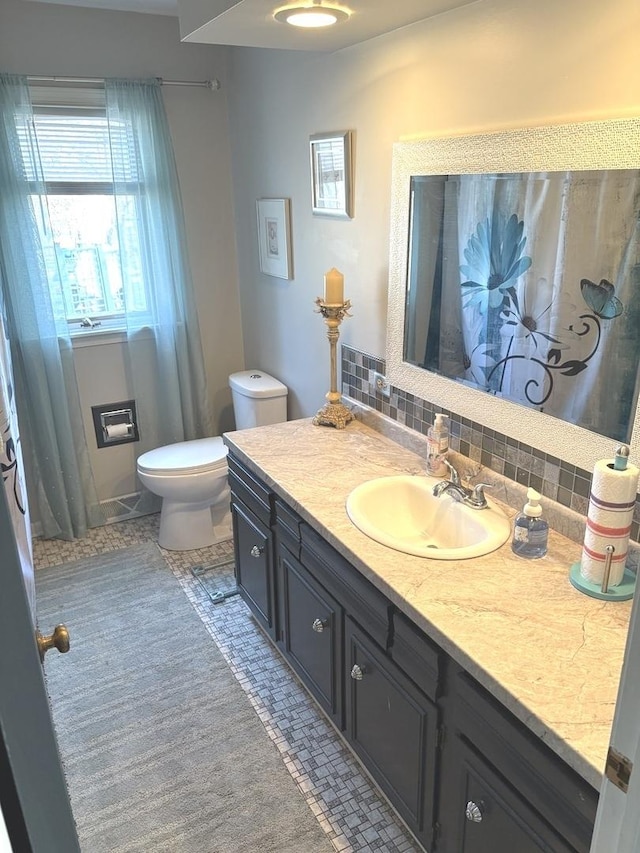 bathroom with decorative backsplash, toilet, vanity, and tile patterned flooring