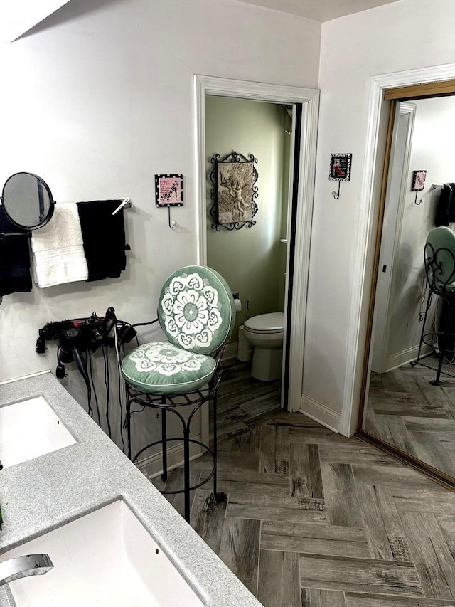 bathroom with toilet and baseboards