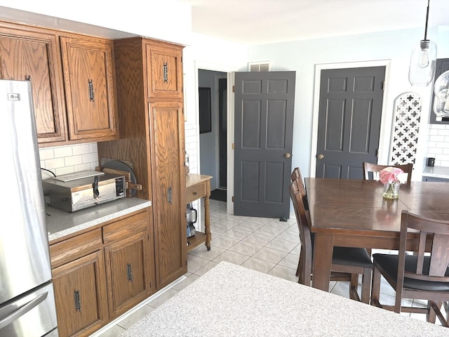 dining room with a toaster, light tile patterned floors, and visible vents