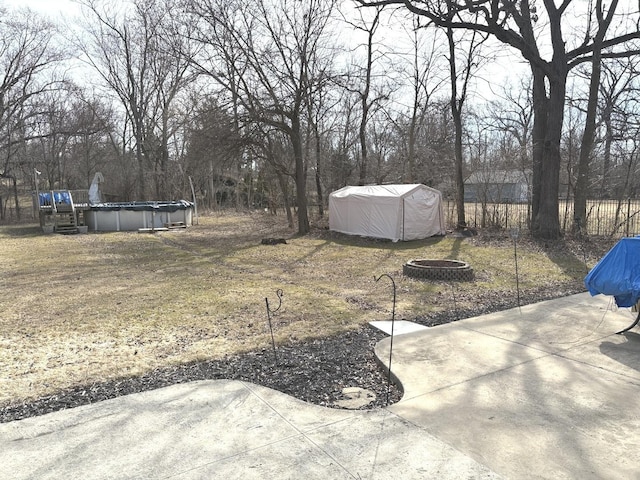 view of yard with a patio area, an outdoor pool, and a fire pit