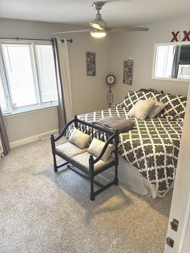 carpeted bedroom featuring a ceiling fan, baseboards, and visible vents