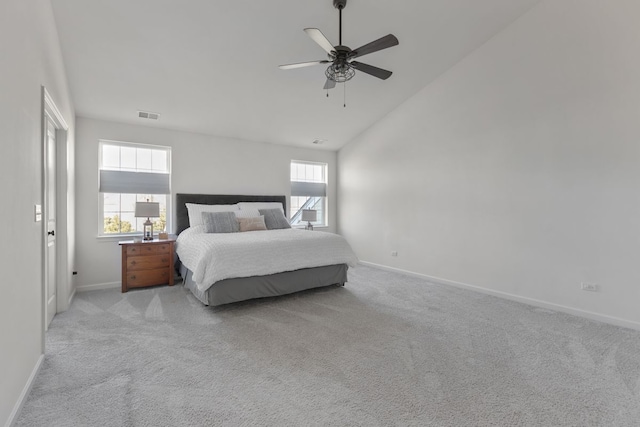 bedroom with visible vents, multiple windows, light colored carpet, and baseboards