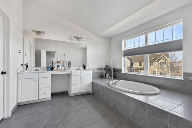 full bathroom featuring tile patterned flooring, a bath, vanity, and vaulted ceiling