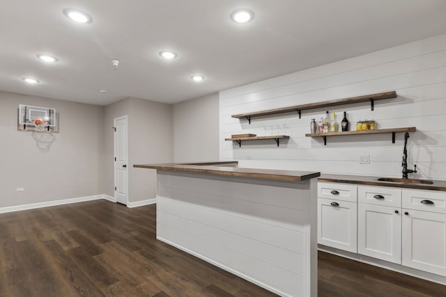 bar featuring indoor wet bar, recessed lighting, dark wood finished floors, and a sink