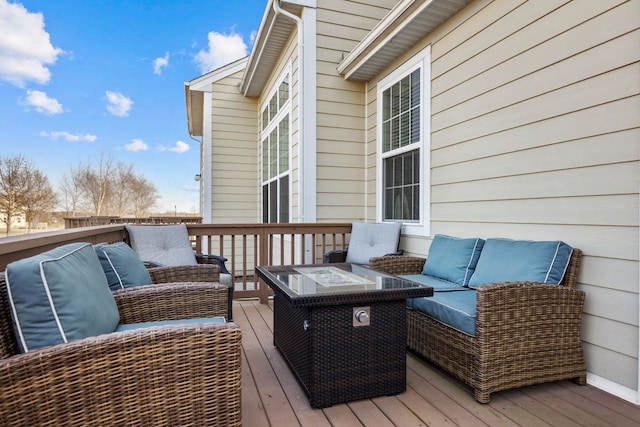 wooden terrace with an outdoor living space with a fire pit