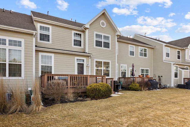 back of house featuring a deck and a lawn