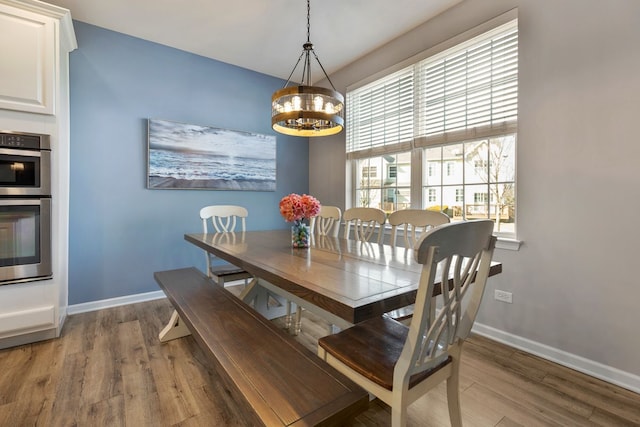 dining room with an inviting chandelier, wood finished floors, and baseboards